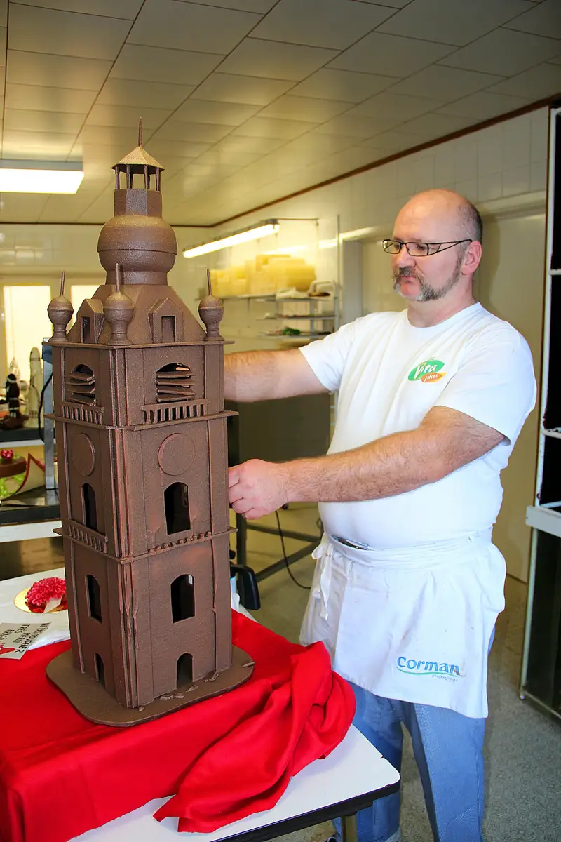 Un cioccolatiere al lavoro su una scultura di cioccolato nel suo laboratorio