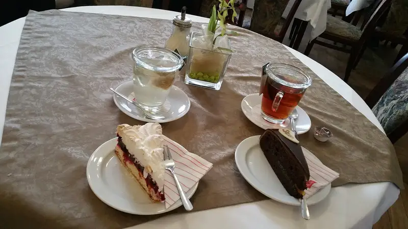 Fette di torta e una tazza di tè sul tavolo di una pasticceria